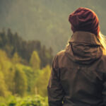 Young,Woman,Standing,Alone,Outdoor,With,Wild,Forest,Mountains,On